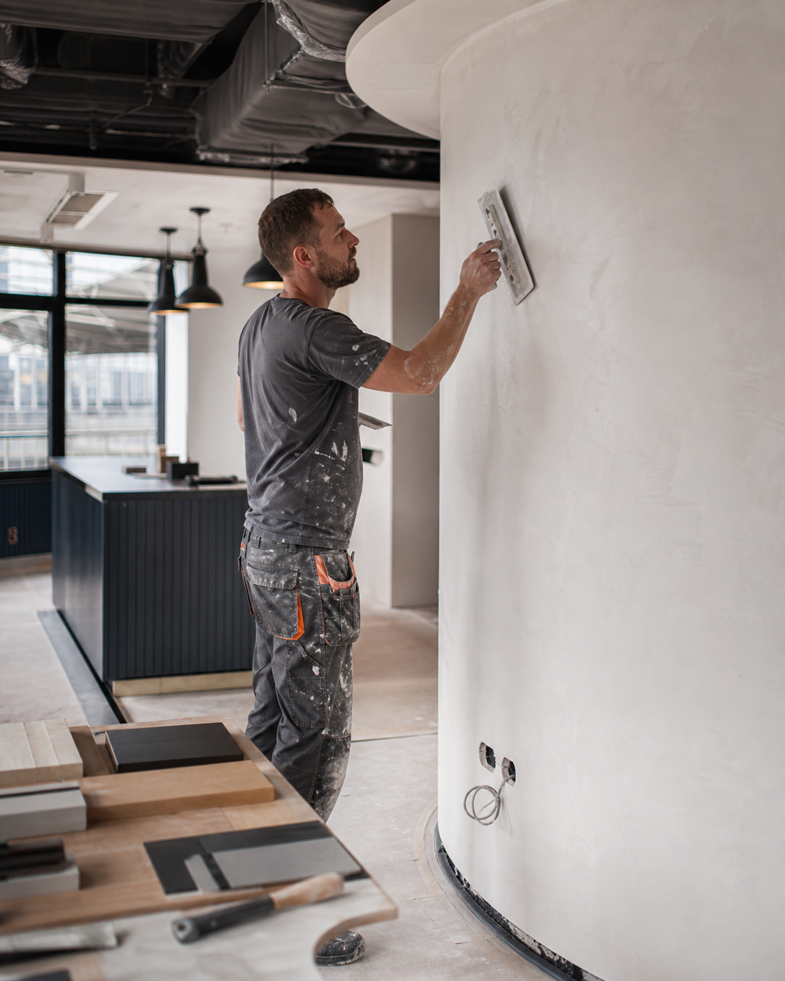 Skilled plasterer finishing a curved wall during a commercial refurbishment